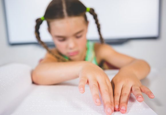 Image of a child using braille